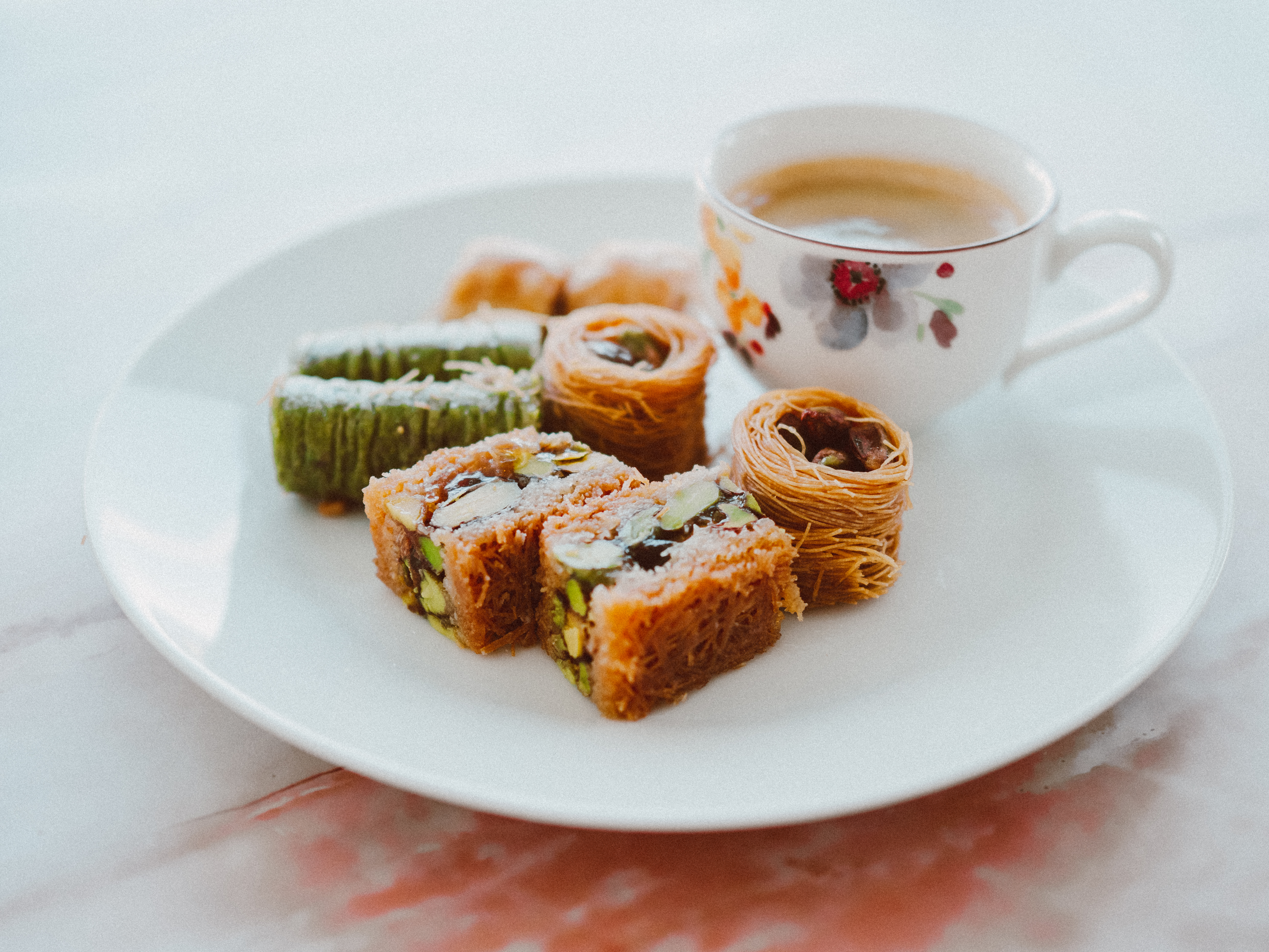 Photo of a plate with baklava and a cup of coffee